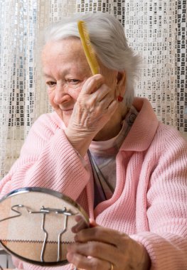 Eski gülümseyen kadın onun saç tarama