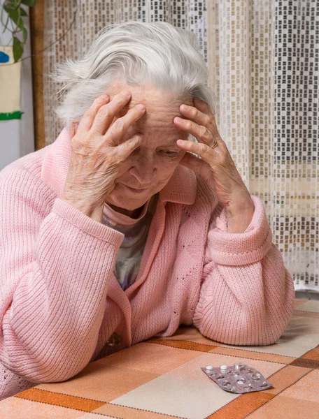 Velha mulher triste segurando pílulas — Fotografia de Stock