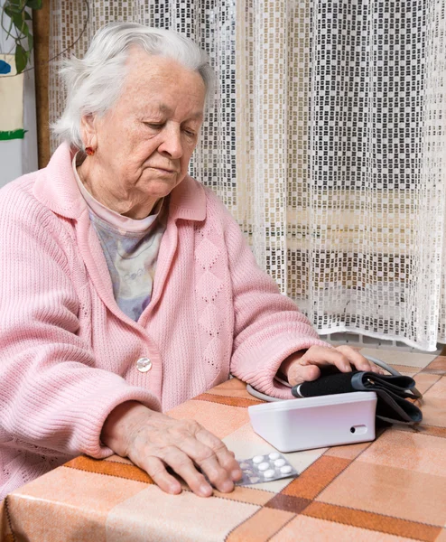 Starym na emeryturze kobieta biorąc ciśnienie krwi — Zdjęcie stockowe