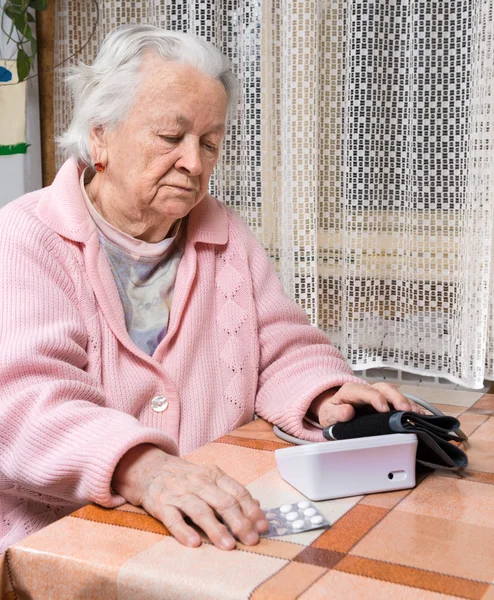 Old  retired woman taking blood pressure — Stock Photo, Image