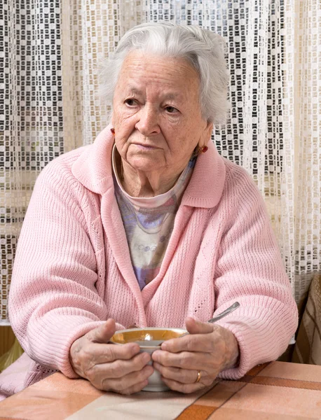 Alte Frau isst zu Hause — Stockfoto