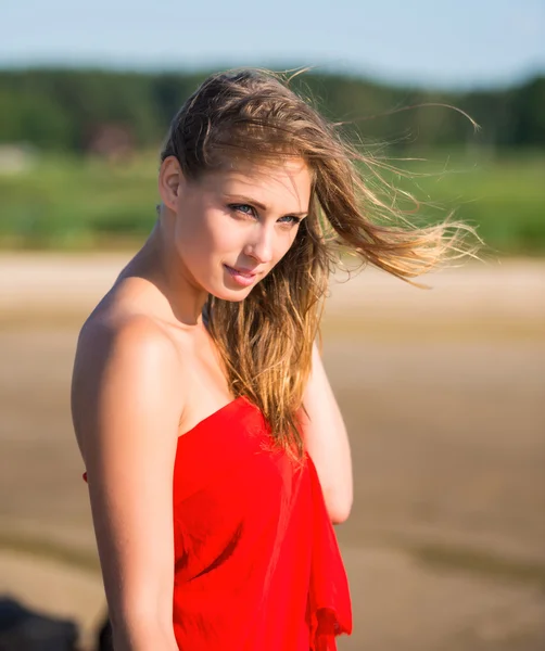 Güzel bir genç kadın kırmızı kumaş — Stok fotoğraf