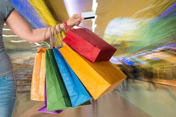 Mulher segurando sacos de compras e cartão de crédito — Fotografia de Stock