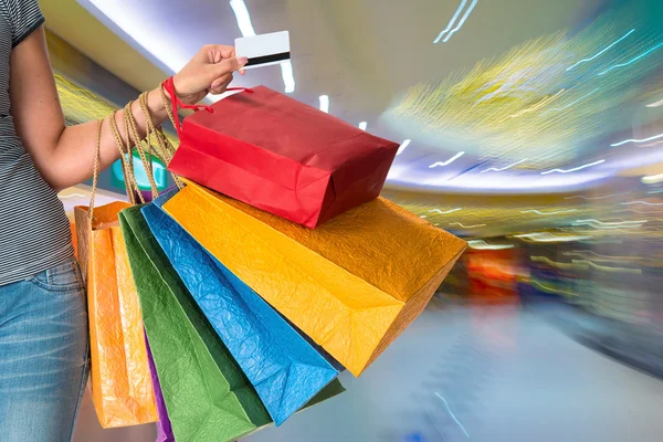 Mujer sosteniendo bolsas de compras y tarjeta de crédito — Foto de Stock