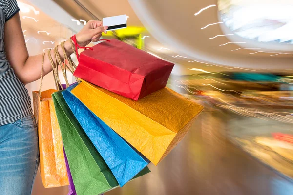 Woman holding shopping bags and credit card — Stock Photo, Image