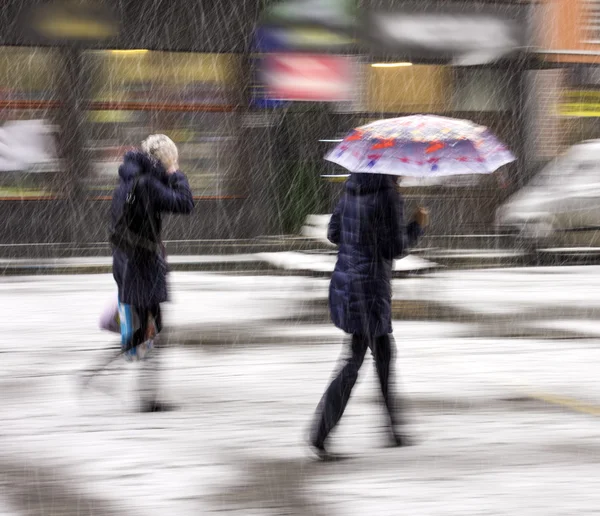 Pessoas andando na rua em um dia de inverno nevado — Fotografia de Stock