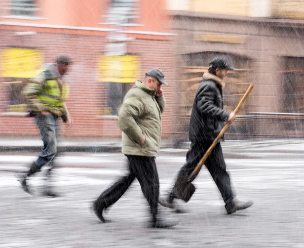 Lidé v ulicích města v zasněžené zimní den — Stock fotografie