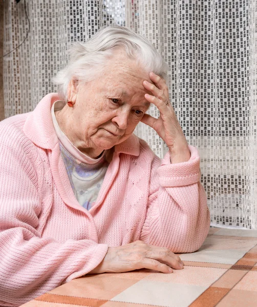 Старая грустная женщина дома — стоковое фото