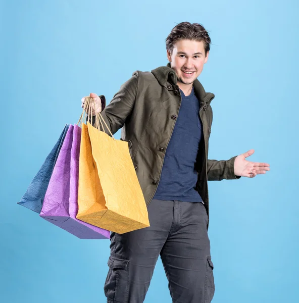 Lachende knappe man met shopping tassen — Stockfoto