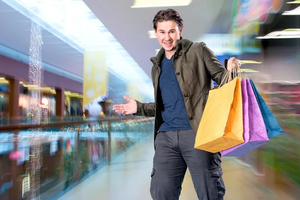 Lächelnder schöner Mann mit Einkaufstüten — Stockfoto