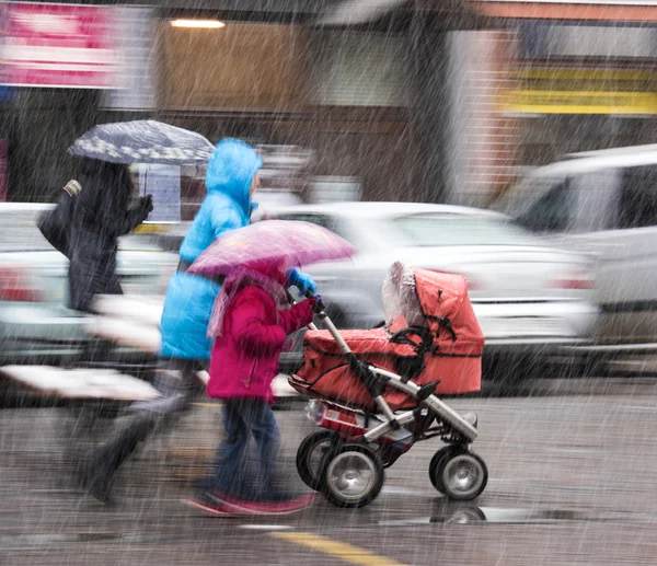 Menschen auf den Straßen der Stadt an einem verschneiten Tag — Stockfoto