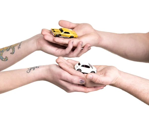 Hands of young couple with miniature cars — Stock Photo, Image