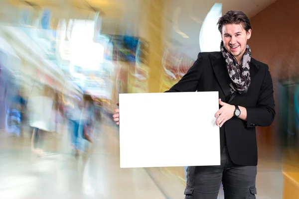 Lächelnder gutaussehender Mann mit großem weißen Brett — Stockfoto