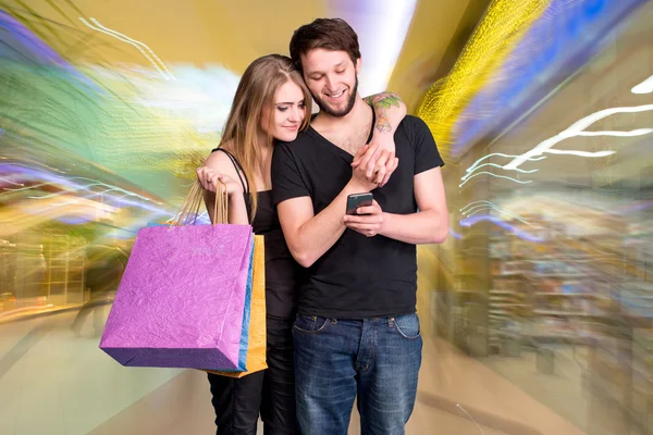 Pareja joven feliz con bolsas de compras — Foto de Stock