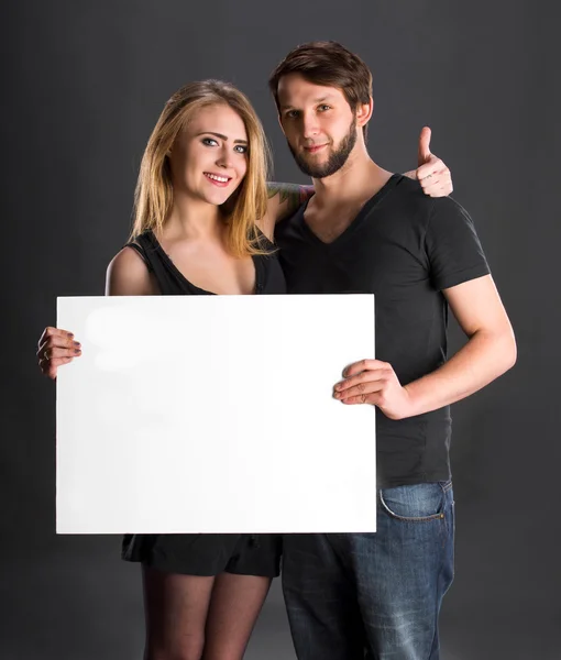 Smiling couple holding big blank white board — Stock Photo, Image