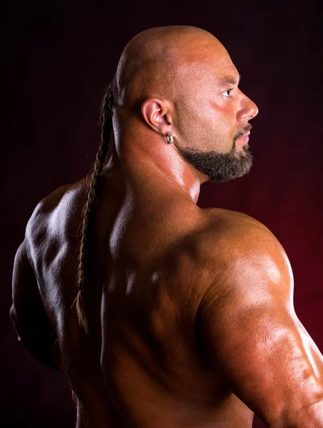 Bodybuilder  demonstrating muscles of the back and arms — Stock Photo, Image