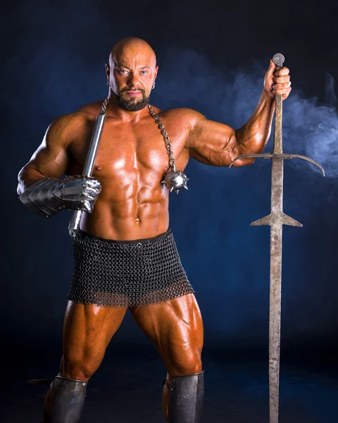 Handsome muscular ancient warrior with a sword — Stock Photo, Image