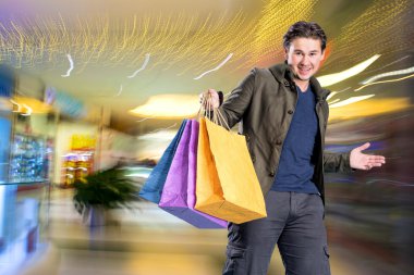 Alışveriş torbaları ile gülümseyen yakışıklı adam 