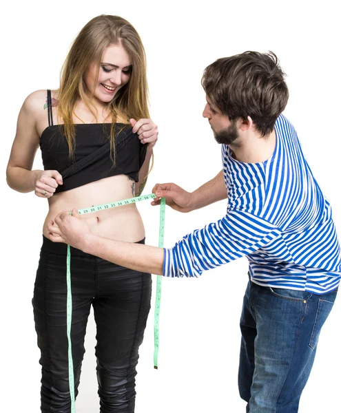 Hombre joven midiendo la cintura de la mujer — Foto de Stock