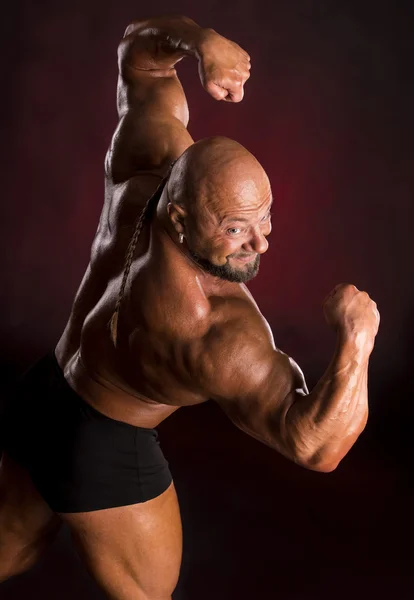 Athlete bodybuilder demonstrating muscles of the back and arms — Stock Photo, Image