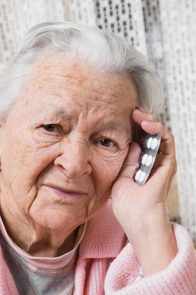 Vecchia donna triste con pillole a casa — Foto Stock