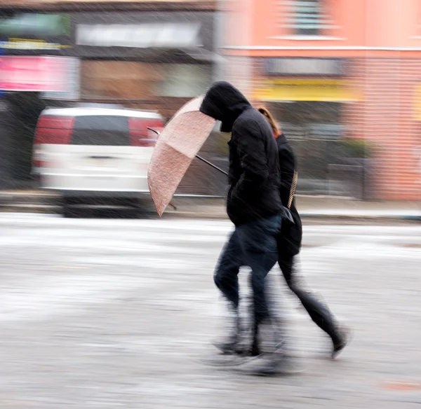 Люди идут по улице в снежный зимний день — стоковое фото