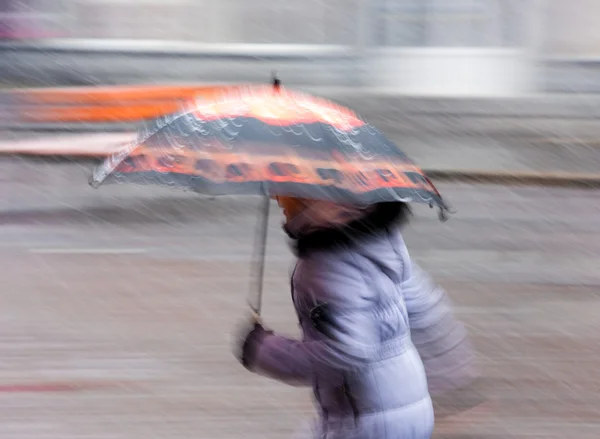 Frau läuft an einem verschneiten Wintertag die Straße hinunter — Stockfoto