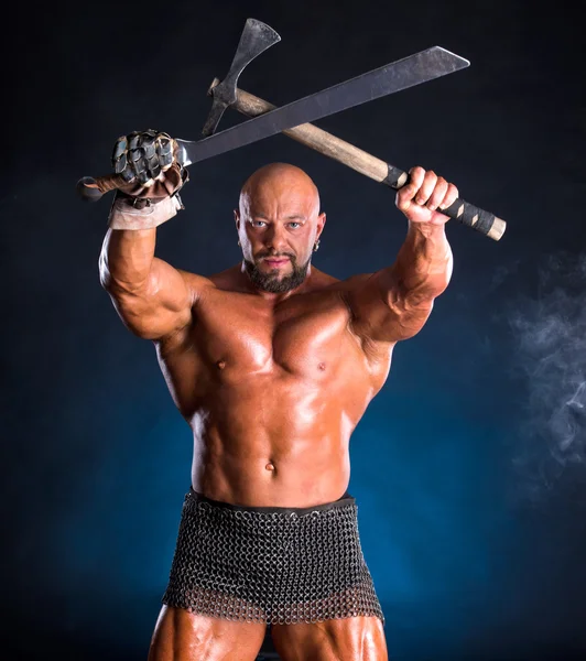 Beau guerrier musclé avec hache et épée — Photo