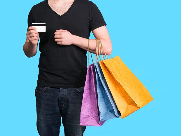 Genç adam alışveriş torbaları ve kredi kartı ile — Stok fotoğraf
