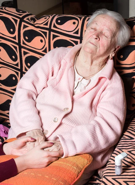 Evde yaşlı bir kadının el ele tutuşarak şefkatli eller — Stok fotoğraf