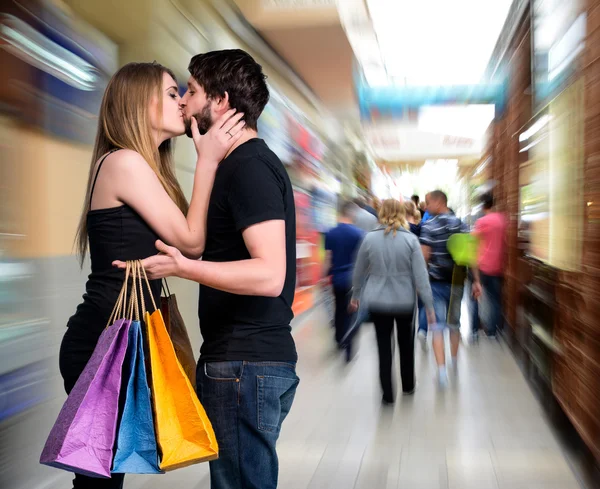 Happy zoenen paar met shopping tassen — Stockfoto