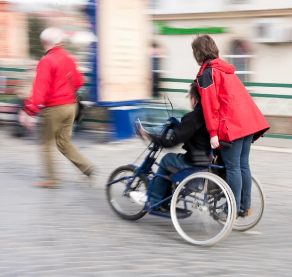 Man with disabilities in a wheelchair accompanied — Stock Photo, Image