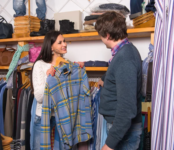 Woman shop assistant showing shirt to man — Stock Photo, Image