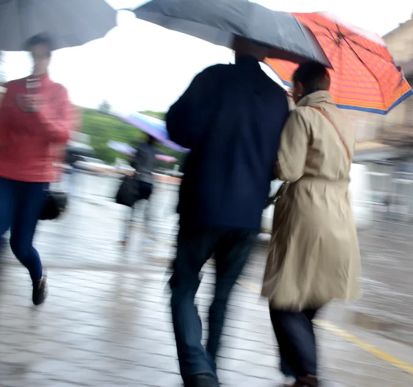 Frauen gehen an einem regnerischen Tag die Straße entlang — Stockfoto