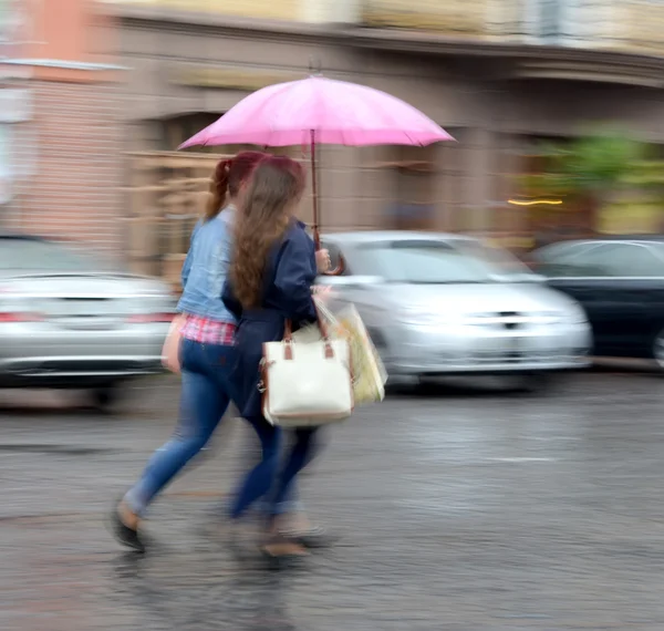 Mulheres descendo a rua em um dia chuvoso — Fotografia de Stock