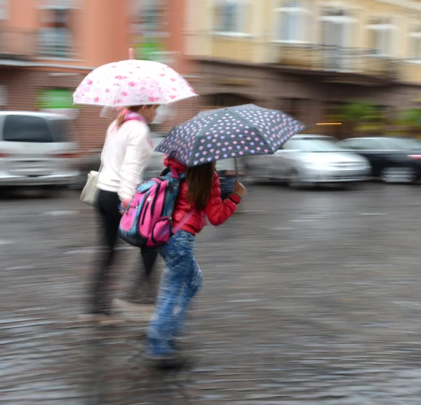 Mulheres descendo a rua em um dia chuvoso — Fotografia de Stock