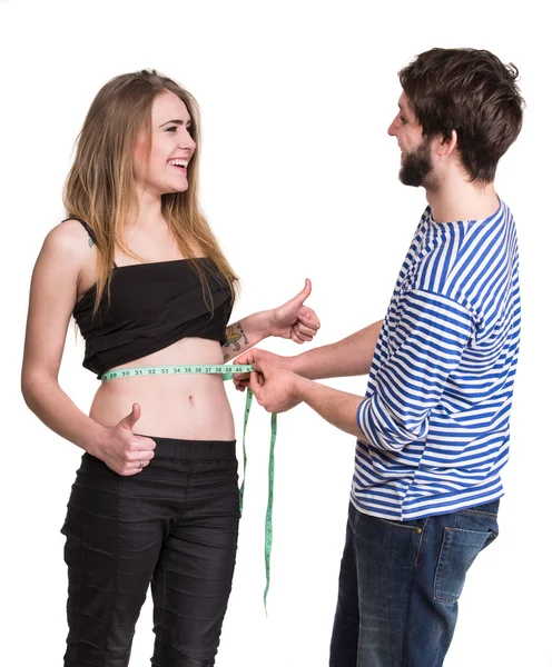 Hombre joven midiendo la cintura de la mujer —  Fotos de Stock