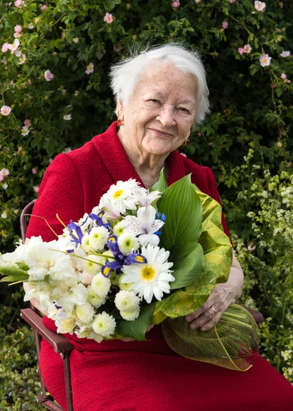 Yaşlı kadınla bir demet çiçek — Stok fotoğraf