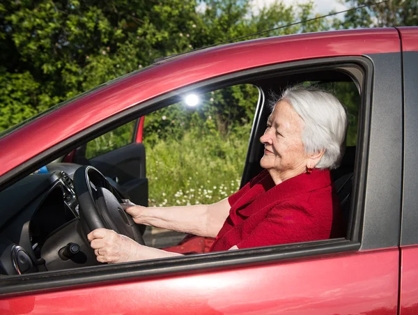 Lächelnde alte Frau sitzt im Auto — Stockfoto