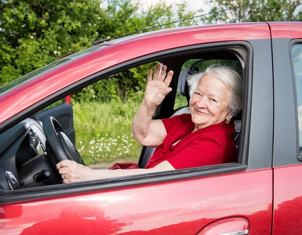 Lächelnde alte Frau sitzt im Auto — Stockfoto