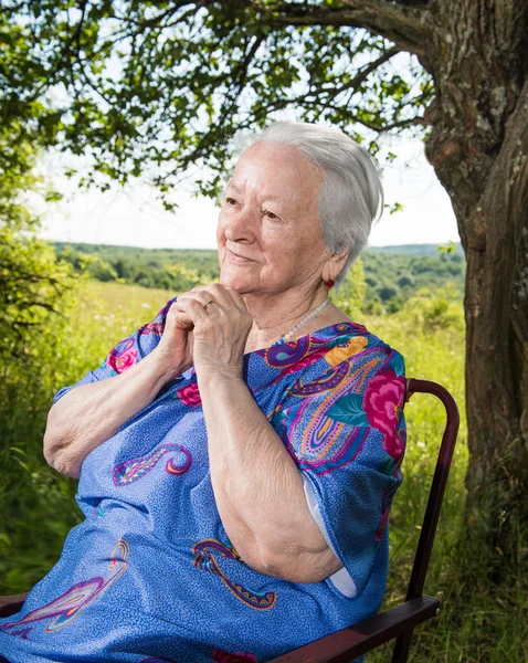 Old woman sitting and praying — Stock Photo, Image
