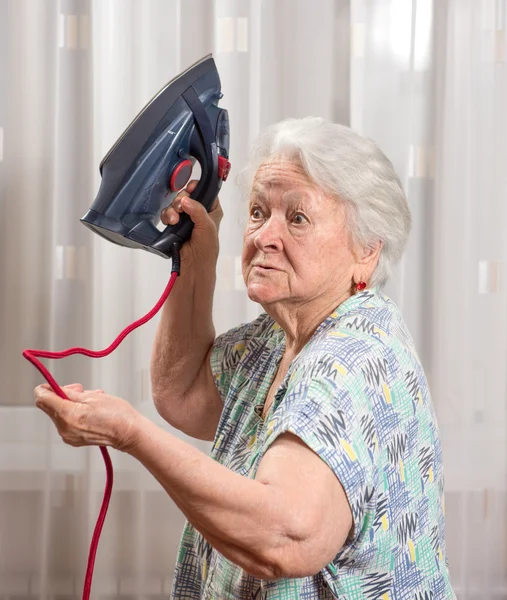 Wütende alte Frau mit Bügeleisen — Stockfoto