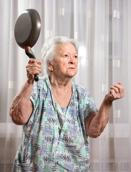 Angry old woman with a pan — Stock Photo, Image