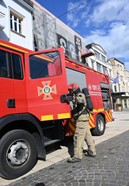 UZHOROD, UKRAINE - 30 EYLÜL 2025: İtfaiyeci ekipmanları şehir merkezindeki acil durum sırasında itfaiye aracına yaklaşıyor