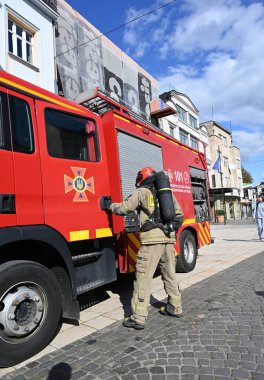 UZHOROD, UKRAINE - 30 EYLÜL 2025: İtfaiyeci ekipmanları şehir merkezindeki acil durum sırasında itfaiye aracına yaklaşıyor