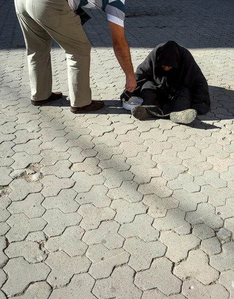 Man gives alms to beggar old woman — Stock Photo, Image