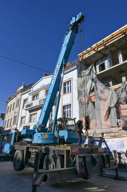  UZHOROD, UKRAINE - 16 Ekim 2025: Bir şehir meydanında sabah Uzhhorod 'da vinç kaldırma malzemeleri ile inşaat çalışmaları