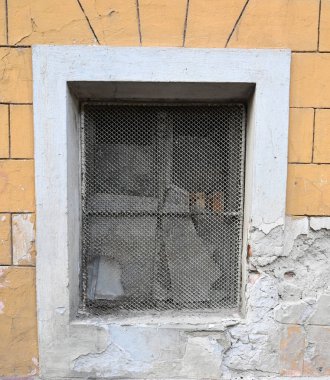 Metal ızgaralı eski bir pencere. Gün ışığında rengini ve eski dokusunu gösteriyor.