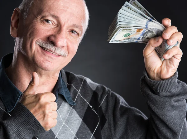 Happy elderly man showing dollars — Stock Photo, Image