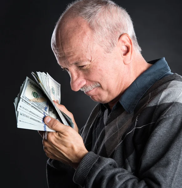 Happy elderly man showing dollars — Stock Photo, Image